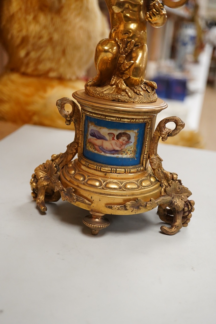 A pair of 19th century brass four light figural candelabra with inset enamel plaques, 48cm high